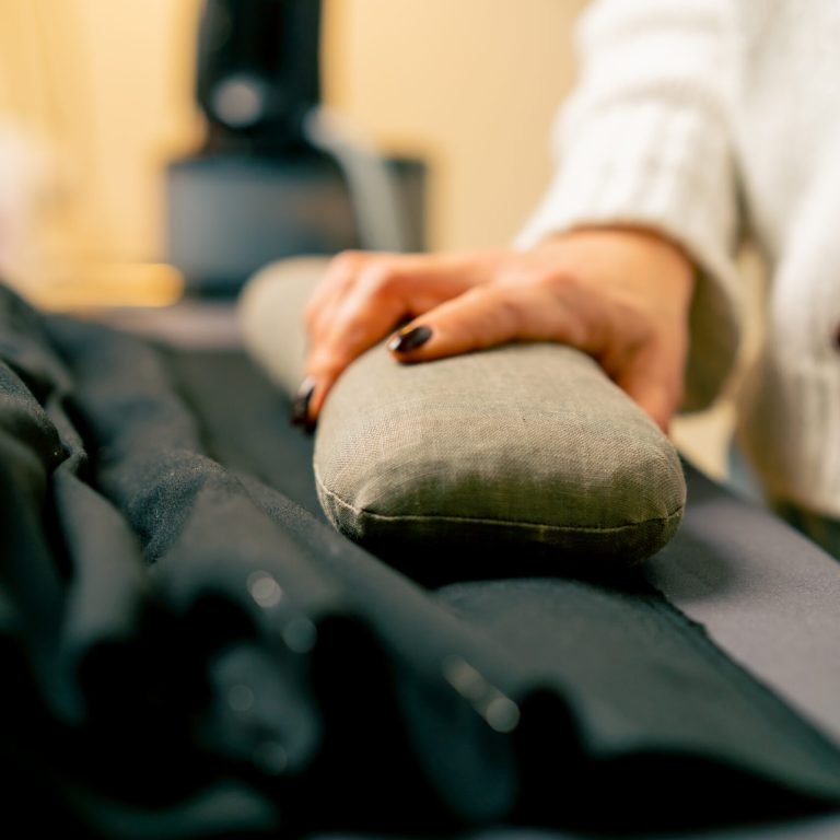 close-up in a sewing workshop a seamstress applies a pillow to cool the fabric